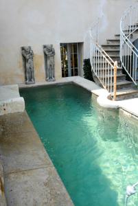 a pool of water with two statues in a building at Le Petit Chateau in Châteauneuf-de-Gadagne
