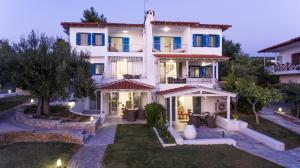 a large white house with a garden in front of it at Acrotel Athena Villa in Elia