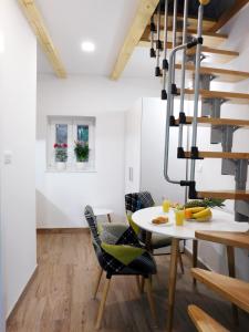 a dining room with a table and chairs and a spiral staircase at Studio apartment Milla in Split