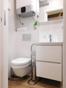a white bathroom with a toilet and a sink at Studio apartment Milla in Split