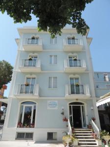 a large white building with balconies and stairs at Hotel Liliana in Rimini