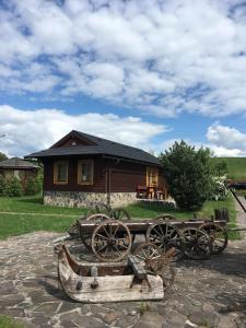 a group of wooden carts parked in front of a house at Tatralandia-Liptov Chatky in Liptovský Mikuláš