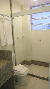 uma casa de banho com um WC e uma cabina de duche em vidro. em Atlântico Centro Apartments no Rio de Janeiro