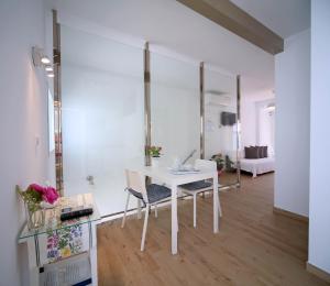 een witte tafel en stoelen in een kamer bij Hotel Casa Rosa in Benalmádena