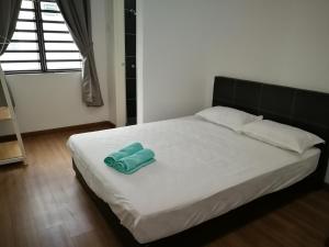 een bed met een paar groene handdoeken erop bij Happy Holiday home in Balik Pulau