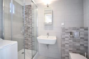 a white bathroom with a sink and a shower at Xanadu Resort in Sianozety +21 photos