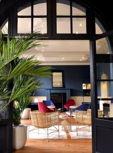 - un salon avec des chaises et une cheminée dans l'établissement Hotel De Diane, aux Sables-dʼOr-les-Pins