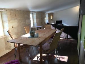 a wooden table and chairs in a living room at Gite la Tropezienne in Blaye