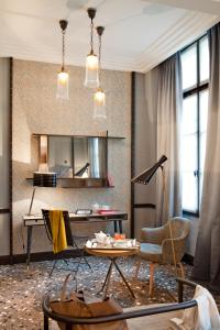 a living room with a table and chairs and a mirror at Hôtel Thérèse in Paris