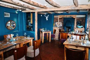 een eetkamer met blauwe muren en houten tafels en stoelen bij Royal Forester Country Inn in Bewdley