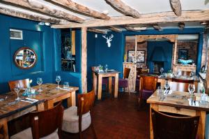 comedor con paredes azules y mesas y sillas de madera en Royal Forester Country Inn, en Bewdley