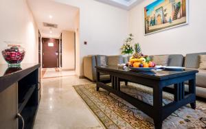 a living room with a table with a bowl of fruit on it at Sahara Hotel Agadir - Adults Only in Agadir