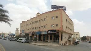 a large building on the corner of a street at Lavina Hotel Apartments in Sakakah