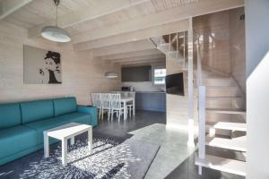 a living room with a blue couch and a kitchen at Xanadu Resort in Sianozety