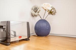 a blue vase with flowers in it next to a microwave at Casa Marcellino Valencia Centro in Valencia