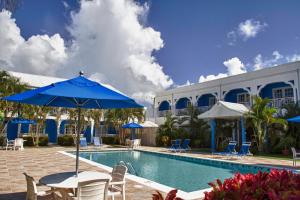 a pool with chairs and a table with an umbrella at Bay Gardens Inn in Gros Islet
