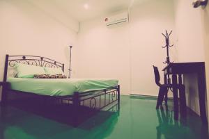 Schlafzimmer mit einem Bett, einem Schreibtisch und einem Stuhl in der Unterkunft The Haven Inn in Malakka