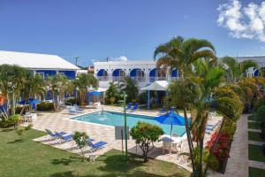 a resort with a pool and palm trees and chairs at Bay Gardens Inn in Gros Islet