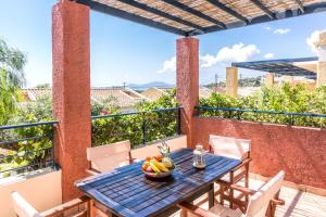 a table on the balcony with a bowl of fruit on it at Akti Barbati Houses by Konnect in Barbati