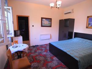 ein Schlafzimmer mit einem Bett, einem Tisch und einem kleinen Tisch in der Unterkunft Hotel Haxhiu in Tirana
