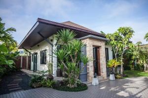 una casa con palme di fronte di Baan Pinya Cosy One Bedroom Executive Bungalow ad Aonang Beach