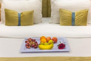 a plate of fruit on a bed in a hotel room at Nawara Dala in Riyadh