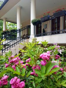 un edificio con fiori rosa di fronte di ŽUPAN apartmani a Soko Banja