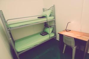 a room with a desk and a bunk bed with a deskablishthritisthritisthritis at The Haven Inn in Melaka +26 photos