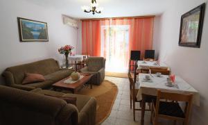 ein Wohnzimmer mit einem Sofa, einem Tisch und Stühlen in der Unterkunft Hotel Haxhiu in Tirana