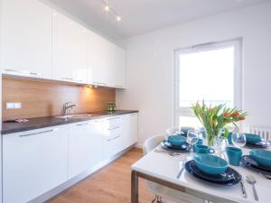 a kitchen with a table with blue dishes on it at VacationClub - Przy Plaży Apartment 10 in Mielno