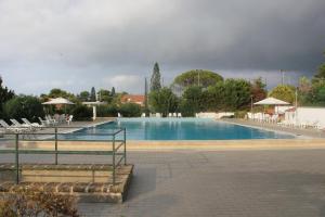 una gran piscina con sillas y sombrillas en Villa Emiri, en Cefalú