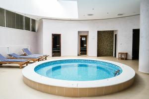 a large swimming pool in a building with two chairs at Park Hotel & Spa Boyana in Sofia