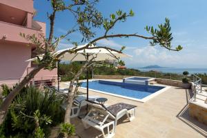a villa with a pool and a view of the ocean at Apartments Silva in Slatine
