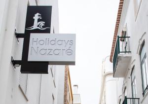 ナザレにあるReal Holidays Nazaréの二棟の間に吊るされた地平線の看板