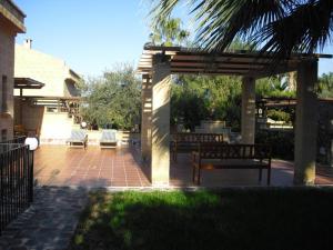 un patio con 2 bancos y un pabellón en Villa Emiri, en Cefalú