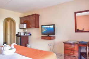 a hotel room with a tv on the wall at Bay Gardens Inn in Gros Islet