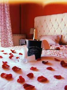 a bottle of champagne and red roses on a bed at Alojamento Local S. Bartolomeu in Trancoso