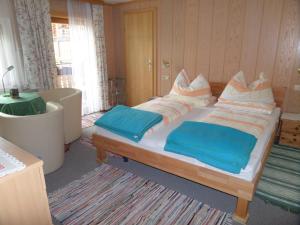 um quarto com uma cama grande e lençóis azuis em Kalcherhof em Ramsau am Dachstein
