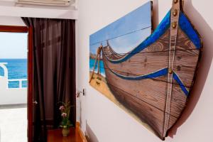 a large painting of a boat hanging on a wall at Irini's Rooms Fteoura in Kamari