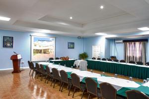 una sala riunioni con tavoli, sedie e un podio di Bay Gardens Inn a Gros Islet Altre 37 foto