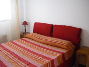 Un dormitorio con una cama con una manta a rayas. en Villa Emiri, en Cefalú