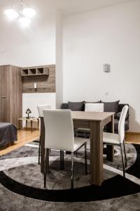 a dining room with a wooden table and white chairs at W2 Synagogue Apartment in Budapest