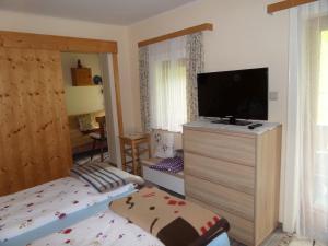 a bedroom with a flat screen tv on a dresser at Kalcherhof in Ramsau am Dachstein