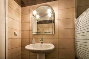 a bathroom with a sink and a mirror at Fouxia Apartments and Studios in Perama