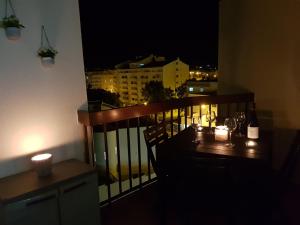 阿爾布費拉的住宿－Appartement piscine Albufeira 205C，阳台配有带蜡烛和葡萄酒瓶的桌子。