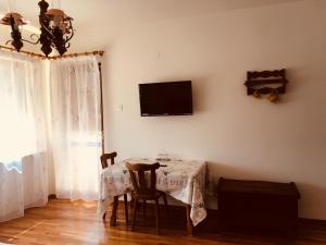 a dining room with a table and a television on the wall at Pensiunea Ambiance in Piatra Neamţ