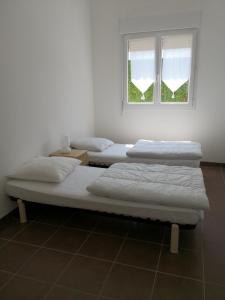 drie bedden in een kamer met een raam bij Domaine de l'Aumone in Agde