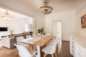a dining room with a wooden table and white chairs at Despina House Ermones in Vátos