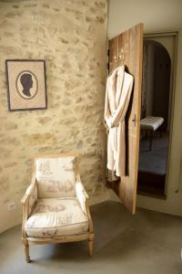 una toalla colgada en una pared junto a una silla en Le Petit Chateau, en Châteauneuf-de-Gadagne