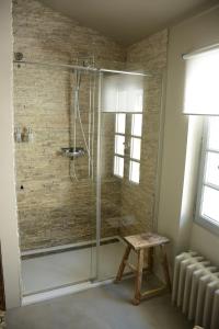 La salle de bains est pourvue d'une douche avec un tabouret. dans l'établissement Le Petit Chateau, à Châteauneuf-de-Gadagne